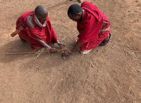 Masai warriors lighting fire using sticks kenya
